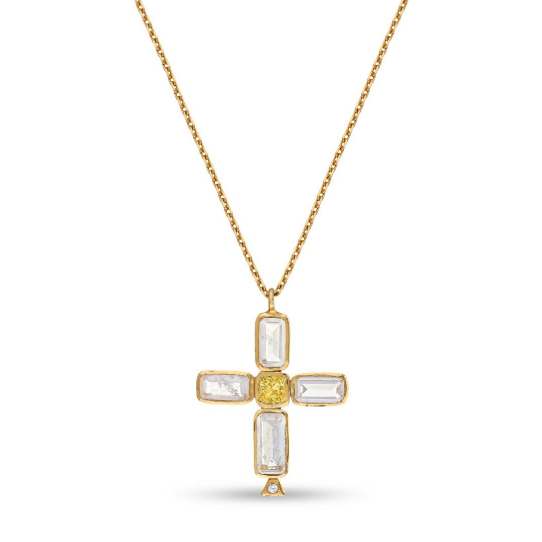 Gold tone cross pendant necklace with baguette style stones and center accent on white background