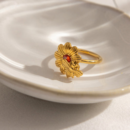 Close view of wholesale stainless steel bee daisy ring with orange zircon on plate
