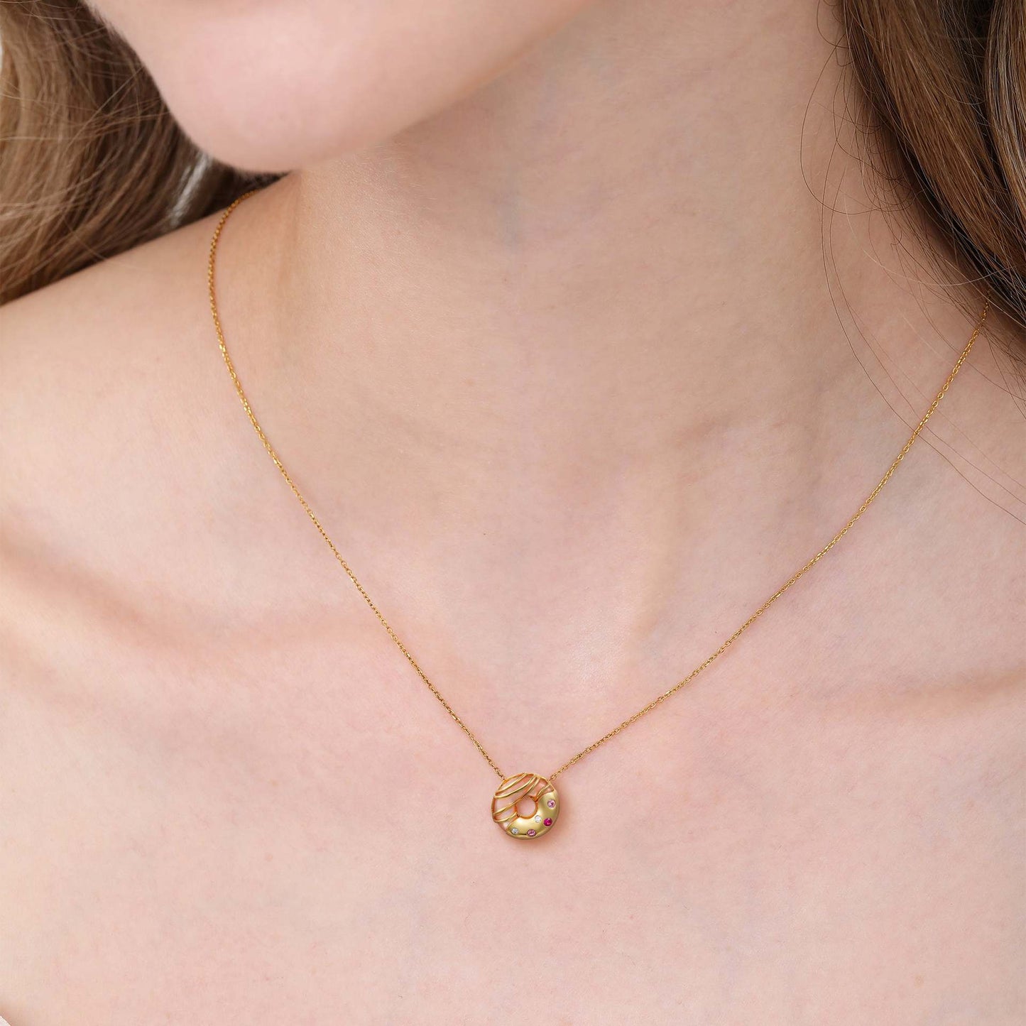 model wearing gold donut dessert pendant necklace with colorful zircon details