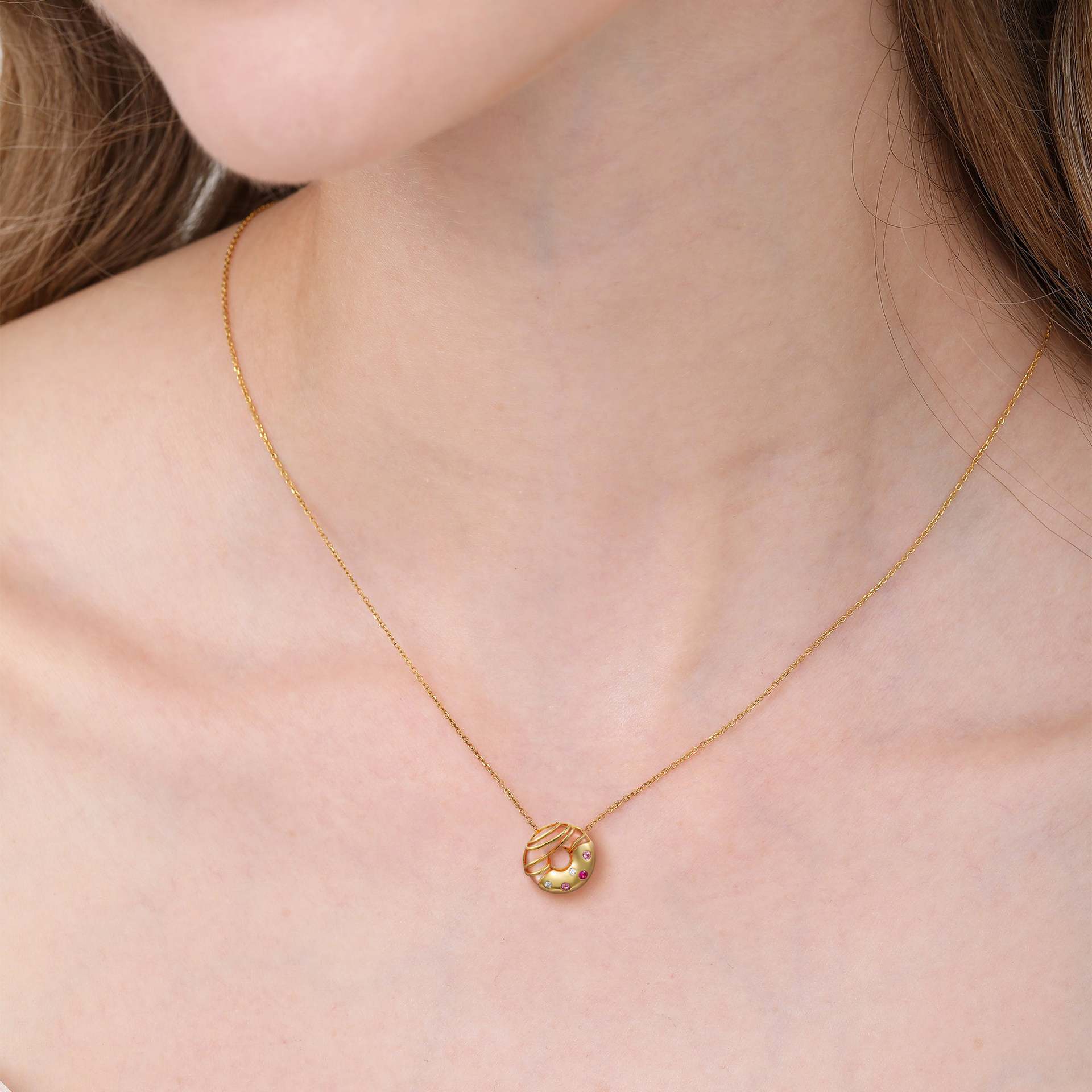 model wearing gold donut dessert pendant necklace with colorful zircon details