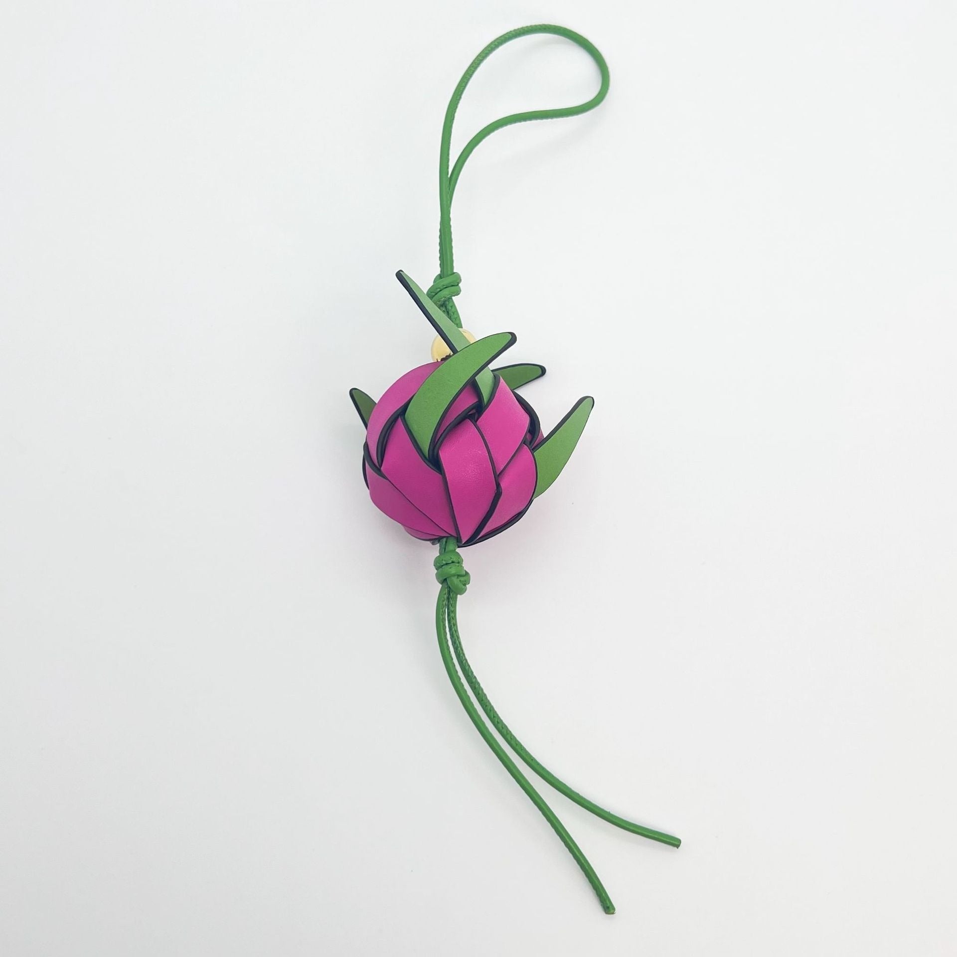 Close-up of leather dragon fruit bag charm with green loop and gold bead