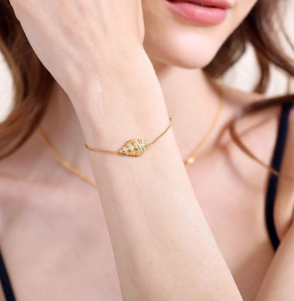 Croissant bracelet gold tone food charm on wrist with sparkle accents