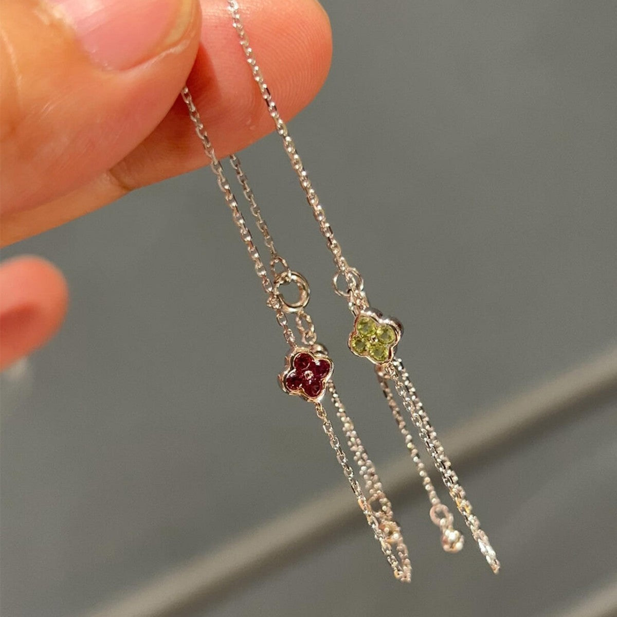 Three delicate sterling silver clover chain bracelets demonstrating elegant draping for boutique display