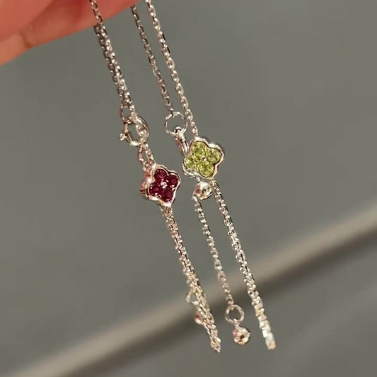 Red and green cz clover sterling silver chain bracelets held by fingers demonstrating premium wholesale quality