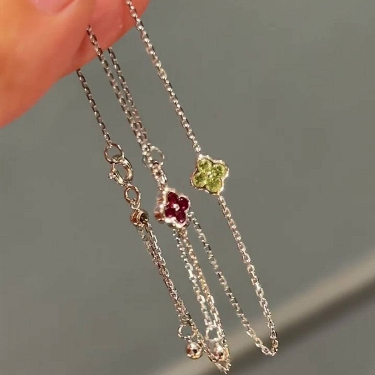 Dainty four leaf clover silver chain bracelets with sparkling cubic zirconia on hand for retail inventory showcase