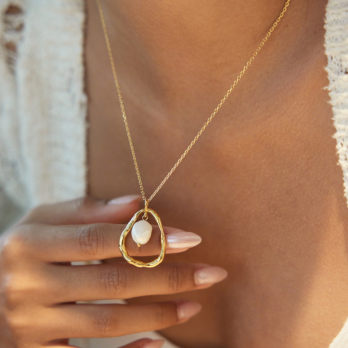 Gold organic frame freshwater pearl pendant necklace shown in a closeup lifestyle view