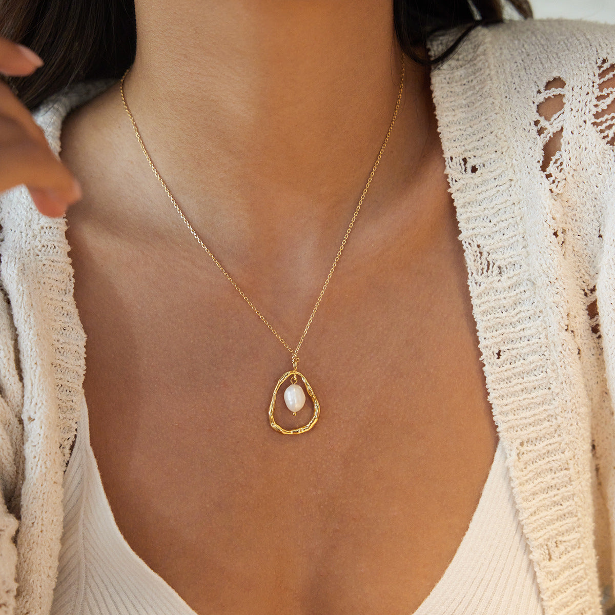Gold freshwater pearl pendant necklace worn with a neutral knit outfit