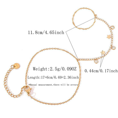 Close up of a gold hand chain bracelet with star charms and round cubic zirconia accents