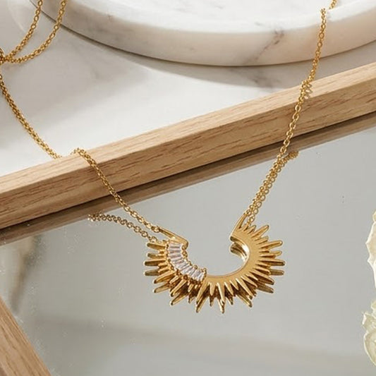 Gold stainless steel sunburst crescent necklace with clear baguette cubic zirconia accents