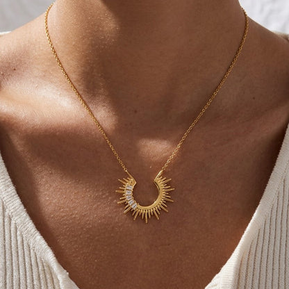 Gold celestial sunburst crescent necklace worn as a statement pendant