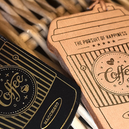 Close up of handmade leather coffee cup keychain and bag charm wholesale accessory showing embossed details for gift exchange ideas