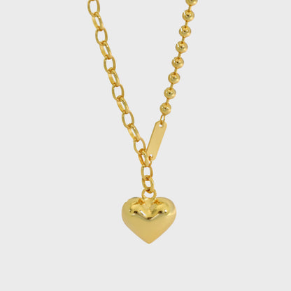 Close-up of gold heart pendant with dual chain design, perfect for minimalist jewelry wholesale and gift box sets.