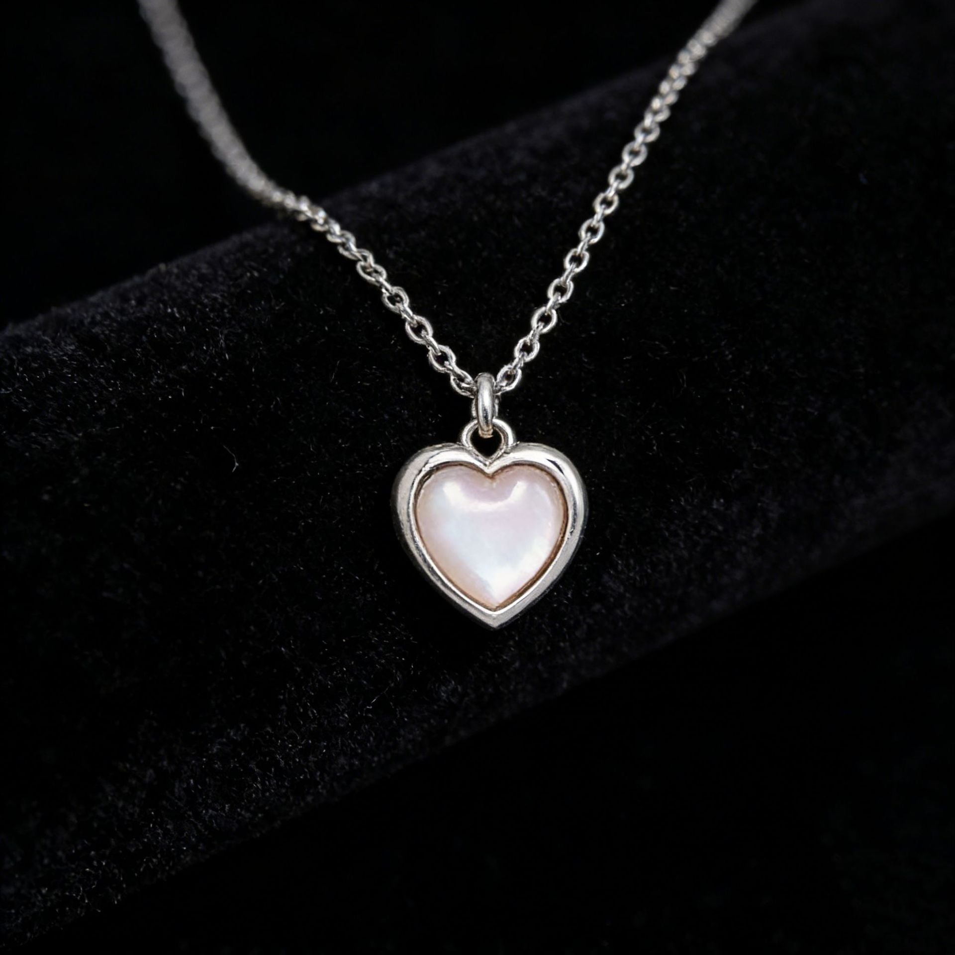 Close up detail of iridescent cat's eye stone heart pendant on S925 silver chain JR Fashion Accessories.