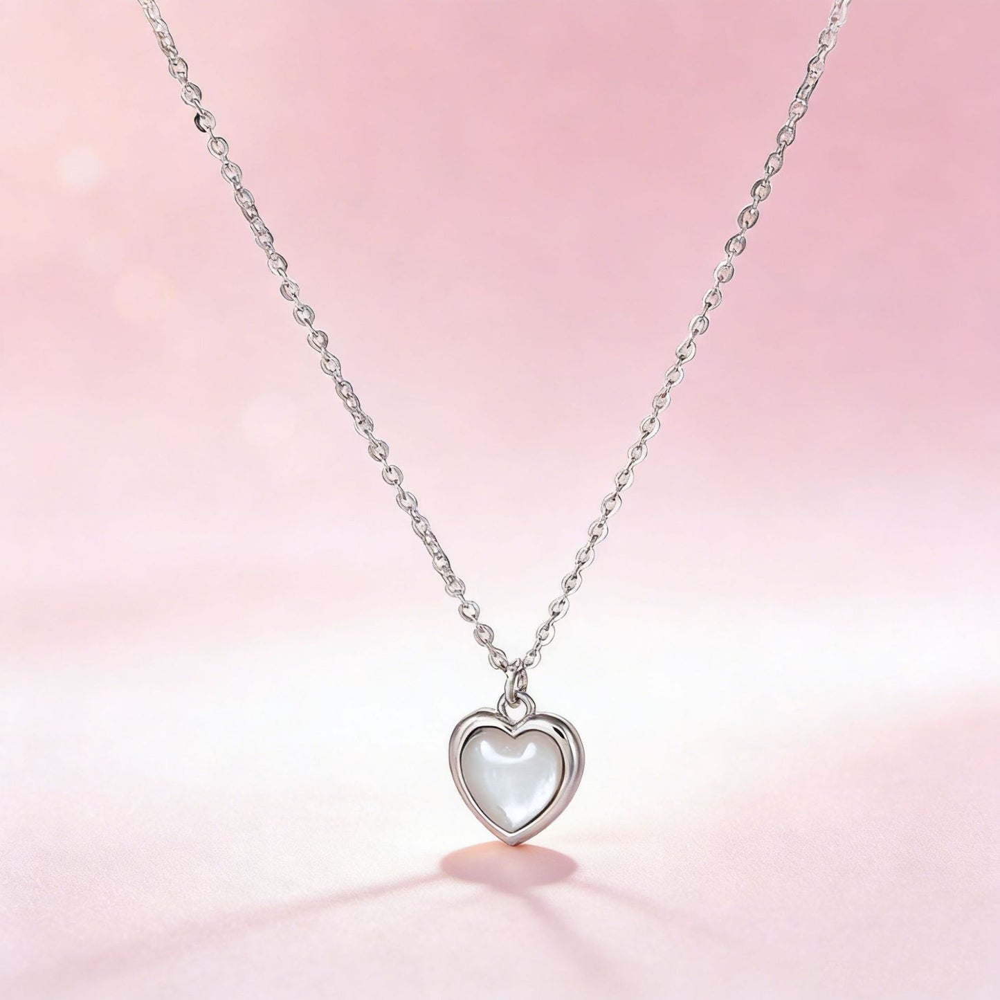 Exquisite heart-shaped cat's eye necklace on pink background for premium jewelry gift collection.