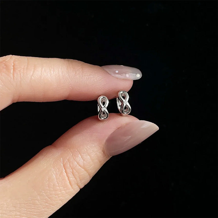 Close up of infinity symbol earrings crafted from S925 sterling silver with polished 18K gold plating