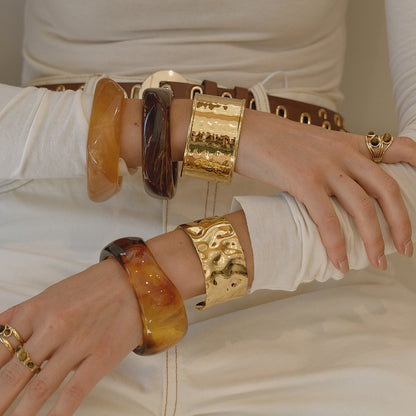 Model wearing multiple resin bangles styled together