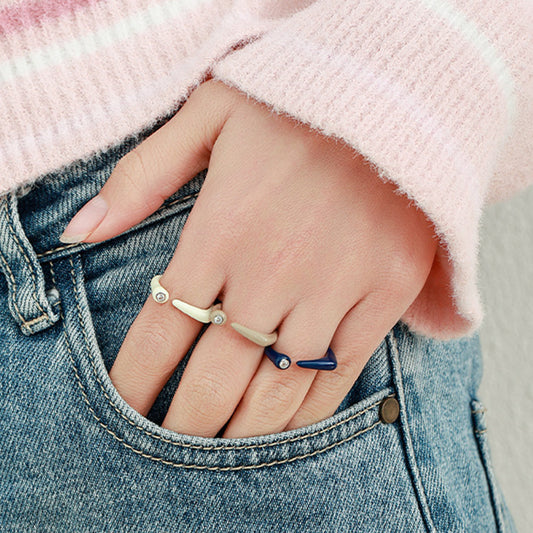 Model wearing minimalist enamel rings with zircon details and open band design