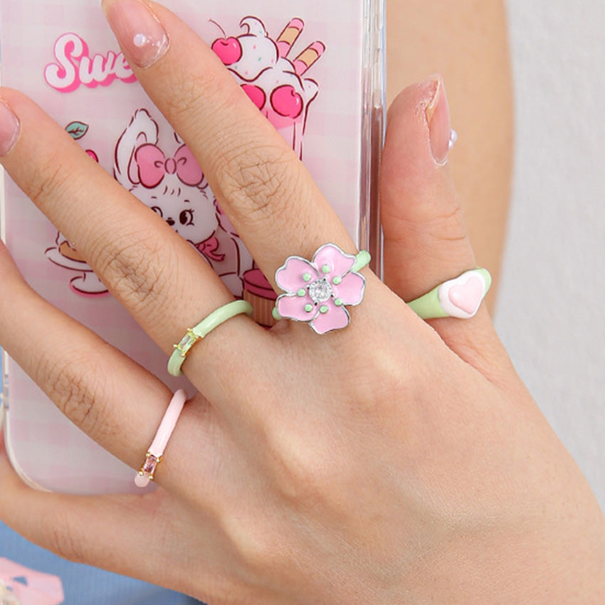 Hand painted pink flower enamel ring featuring a sparkling zircon centerpiece
