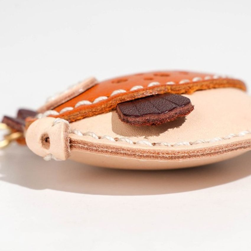close-up of hand sewn leather pufferfish keychain fins and stitching – handmade kawaii keychain for bags or gifts