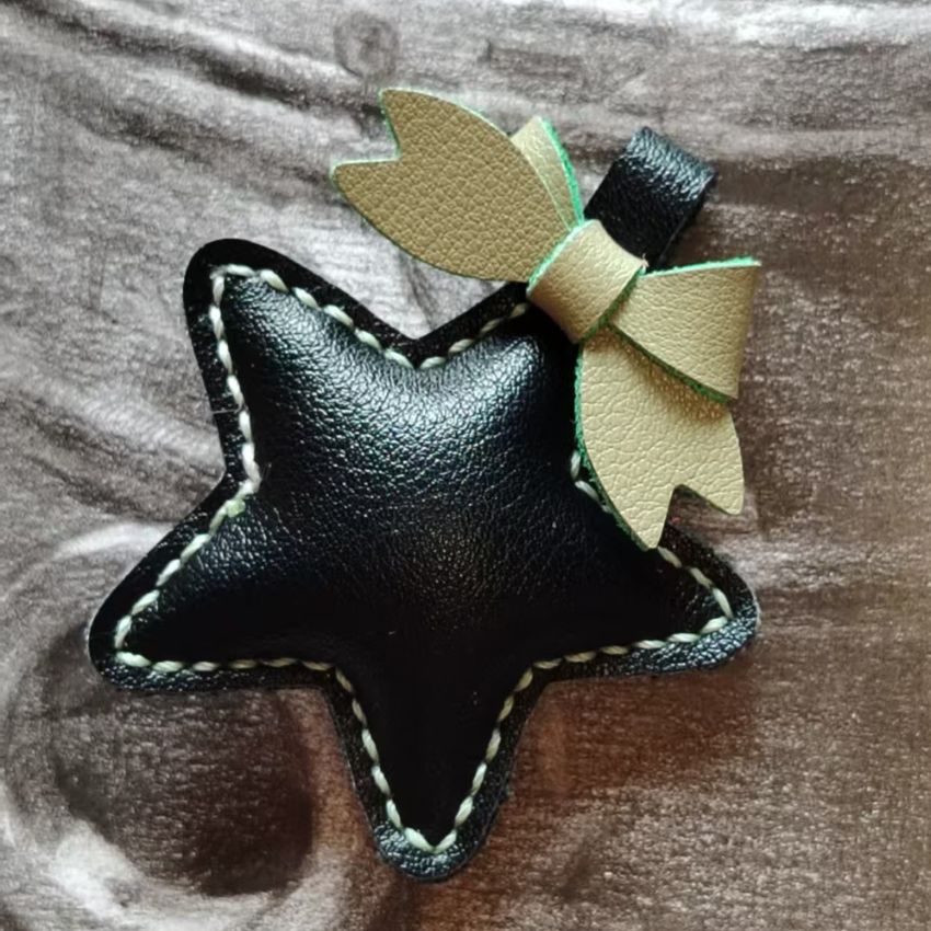 Black leather star accessory with beige bow, stylish handmade leather ornament