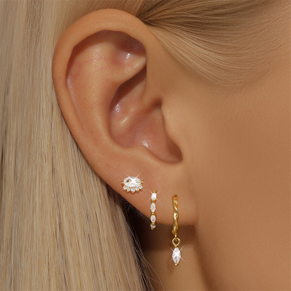 Model wearing JR Fashion Accessories gold star engraved hoops and crystal flower stud 5 piece set for multi piercing.