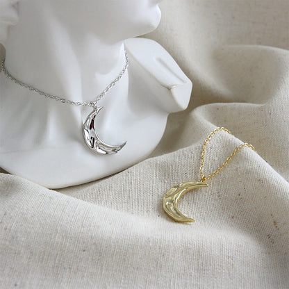 Close-up of gold hammered crescent pendant on chain, elegant and shiny design ideal for 925 silver jewelry bulk and wholesale.