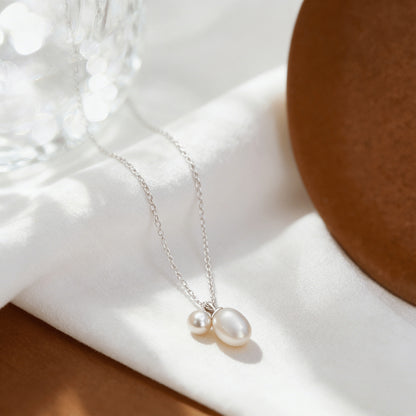 Wholesale 925 silver natural pearl necklace displayed on white fabric with delicate chain