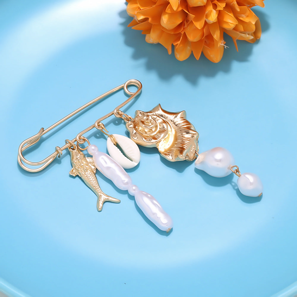 Ocean pearl shell safety pin brooch attached to blue denim as a decorative waist cincher