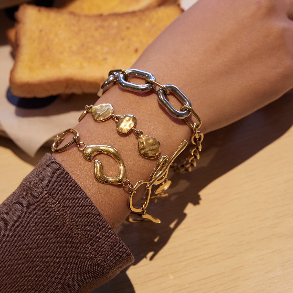 Organic shape link bracelet gold t bar closure minimal styling on wrist