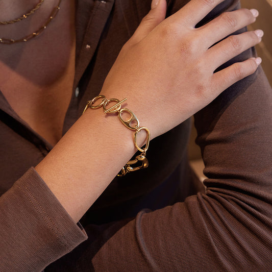 Gold t bar bracelet organic shape link bracelet stacked style on wrist
File name