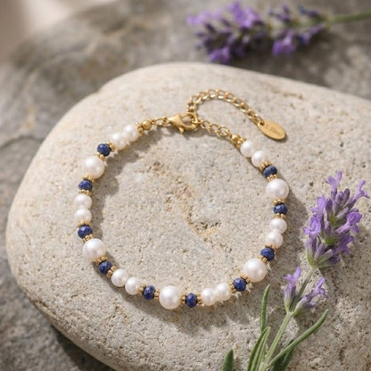 Pearl beaded bracelet with blue stone accents gold tone spacers flat lay