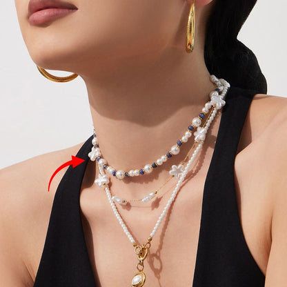 model wearing pearl beaded choker necklace with blue bead accents