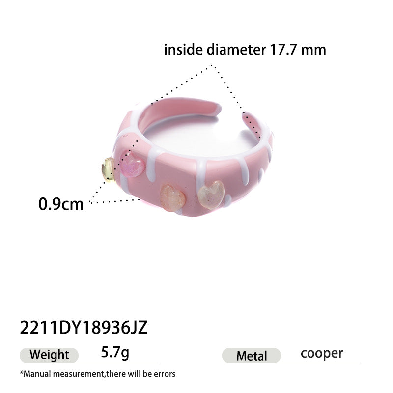 Pink enamel ring with white dripping cream and heart accents.