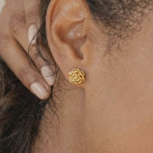 Close-up video of a model wearing JR Fashion Accessories 18K gold plated rose stud earrings, showcasing the 3D floral detail and metallic luster.
