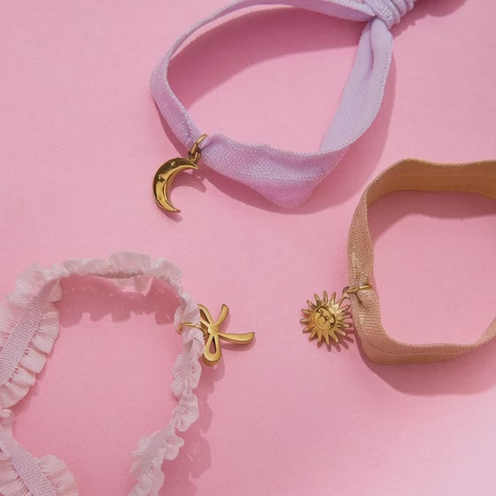 Set of 3 stainless steel charm bracelets featuring bow, sun, and moon pendants on elastic ribbon bands for wholesale jewelry