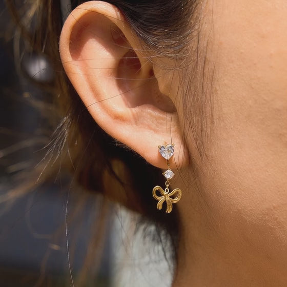 Gold tone bow tassel drop earrings with teardrop zircon