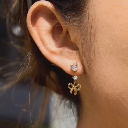 Gold tone bow tassel drop earrings with teardrop zircon