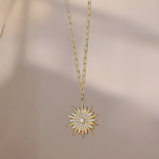 close up video of gold stainless steel sunburst pendant necklace with cubic zirconia