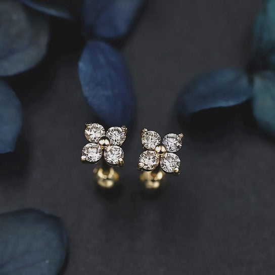 Rotating display of S925 sterling silver four leaf clover earrings with 18K gold plating and cubic zirconia stones for wholesale jewelry buyers and boutique collections