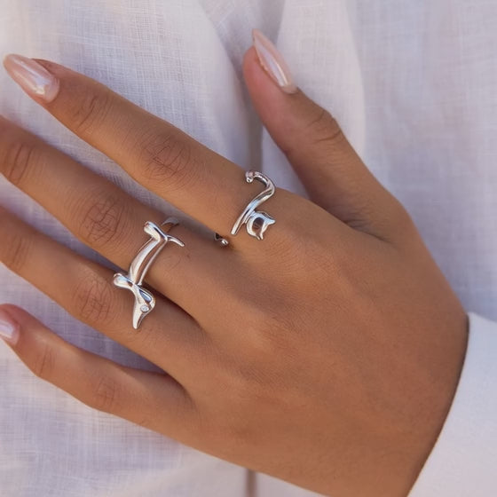 Model wearing gold dachshund and cat open rings for minimal animal themed styling