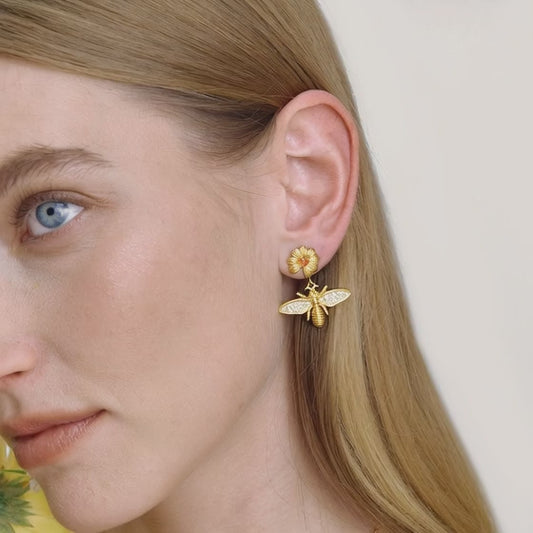 close up video of gold stainless steel daisy bee drop earrings with red zircon flower stud