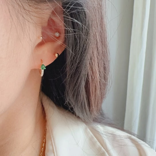 Rotating display of S925 sterling silver 18K gold plated teardrop CZ huggie earrings with purple and green cubic zirconia stones for wholesale jewelry buyers and boutique collections