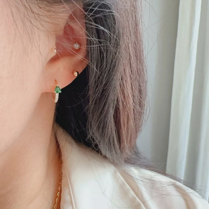 Rotating display of S925 sterling silver 18K gold plated teardrop CZ huggie earrings with purple and green cubic zirconia stones for wholesale jewelry buyers and boutique collections