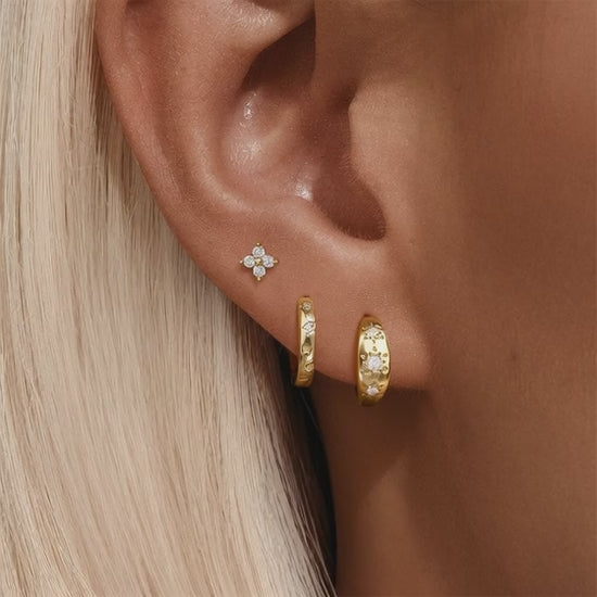 Video demonstration of the sparkling light reflection on gold star engraved hoops and flower stud earrings.