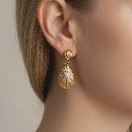 Model wearing the gold star pearl drop earrings showing the 18K gold luster and movement.
