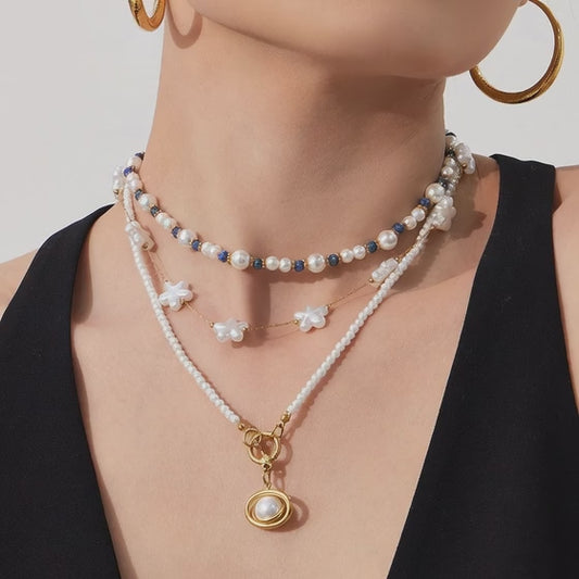 close up video of pearl beaded choker necklace with blue bead accents