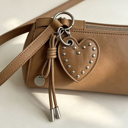 Taupe PU leather studded heart charm attached to a brown handbag