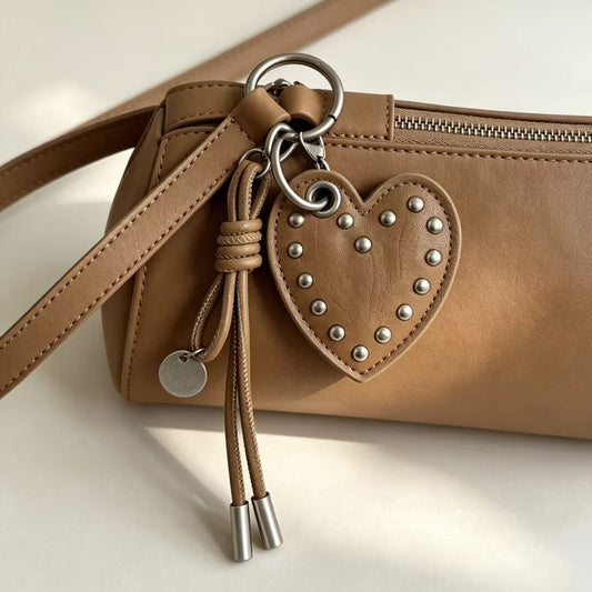 Taupe PU leather studded heart charm attached to a brown handbag