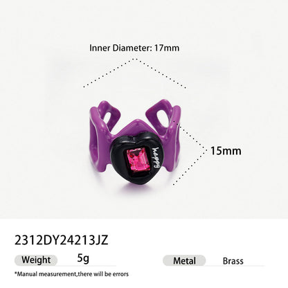 Purple geometric hollow brass ring with black heart and pink gemstone.