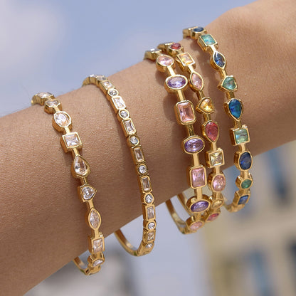 Stacked gold bangles with colorful mixed shape gemstone details